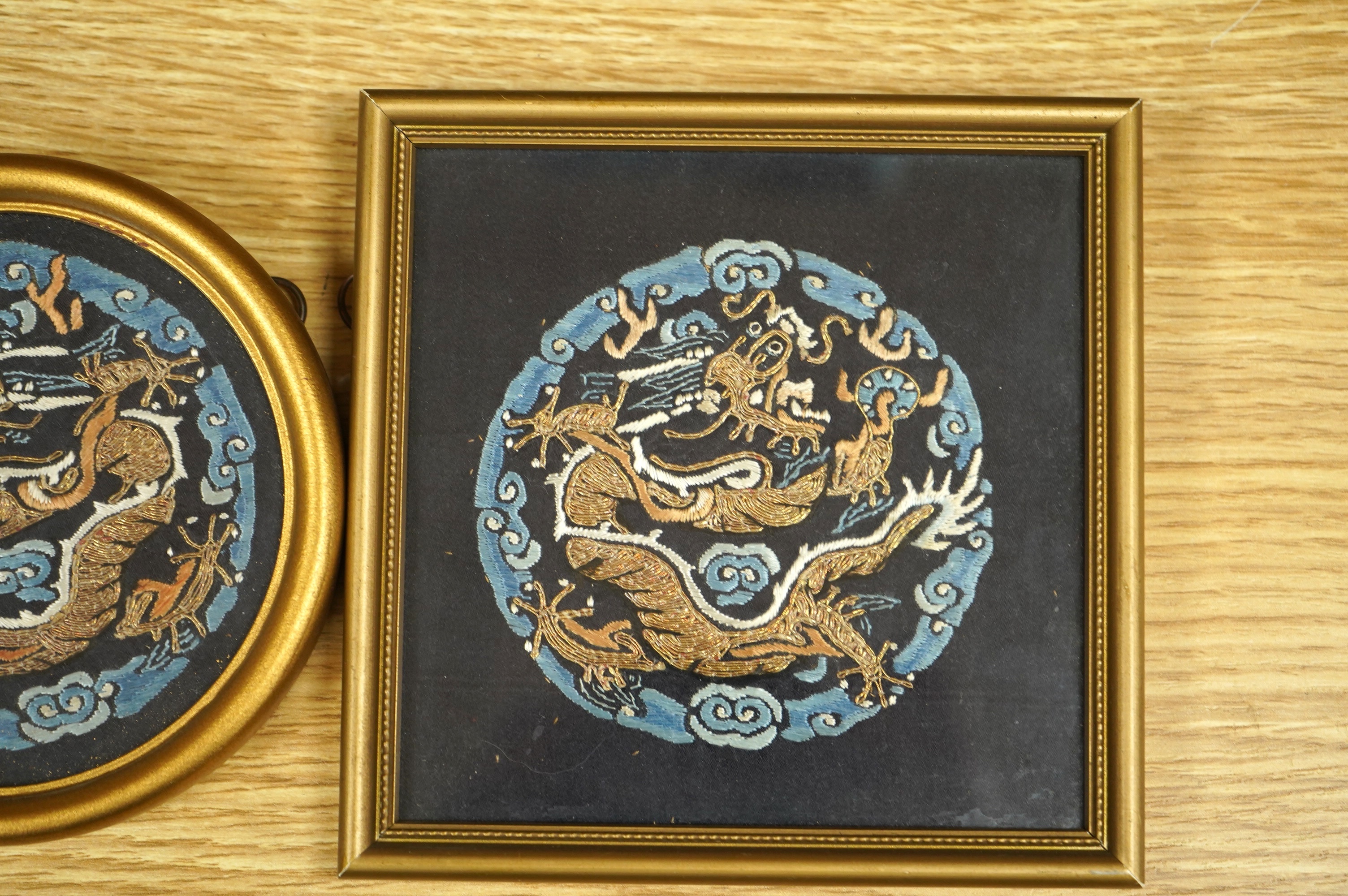 Three Chinese early 20th century embroidered roundels of five claw dragons, embroidered in gold thread and blue silk thread possibly symbolic motifs cut from a robe, embroidery 9cm diameter. Condition - embroidery good,